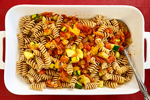 whole grain pasta cooked in a baking dish with vegetable sauce